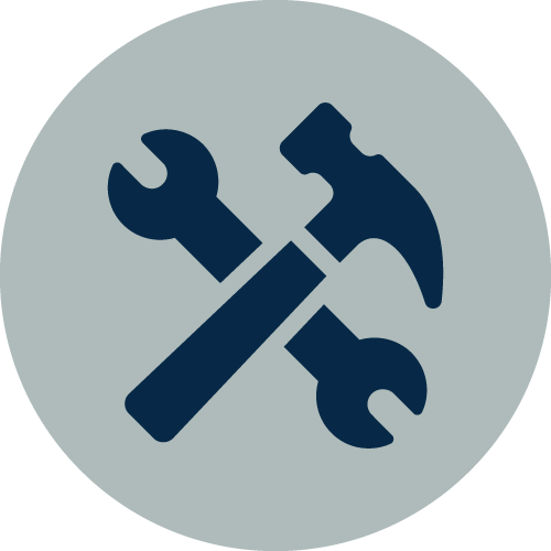 A dark blue hammer and wrench crossed over each other on a light gray circular background, symbolizing tools or construction-related themes.