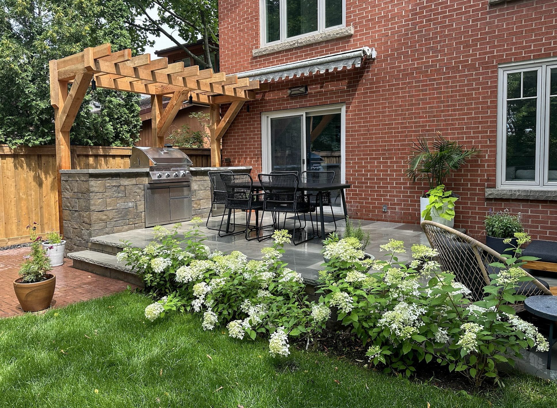 outdoor natural stone kitchen with wooden pergola.